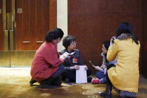 2015年03月05日，北京，全国政协十二届三次会议举行小组讨论，在妇联界别会议室外，政协委员尚绍华与记者席地而坐，回答记者提问。