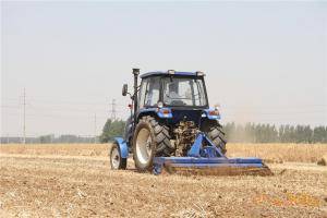 合作社拖拉机正在对土地进行旋耕作业。